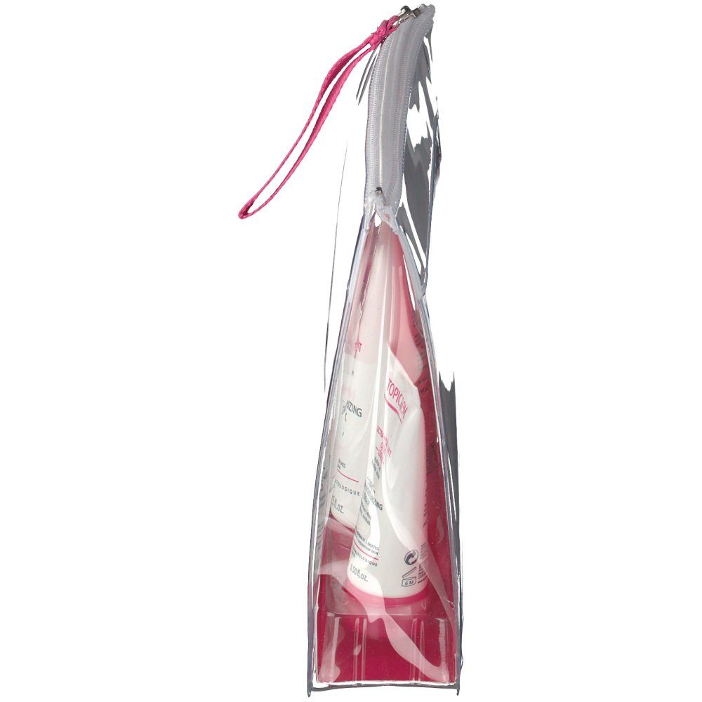 Vue latérale de la trousse de voyage transparente Topicrem. Boucle de préhension rose. Produits visibles à l'intérieur.