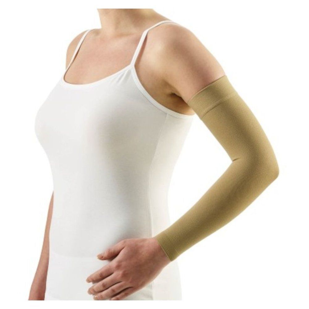 Beige armkous op de arm van een persoon. Product gedragen op de arm. Geen verdere details zichtbaar.