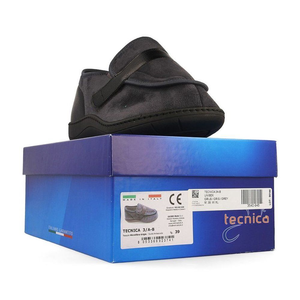 Chaussure de confort grise sur boîte bleue. Semelle noire, fermeture velcro. Sur la boîte : nom du produit, taille 39.
