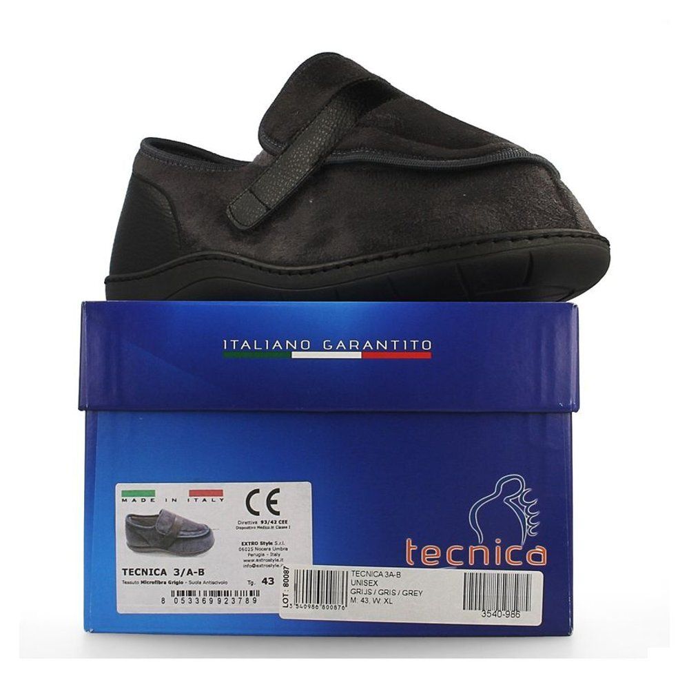 Chaussure de confort grise sur boîte bleue. Semelle et fermeture velcro noires. Informations produit sur la boîte.