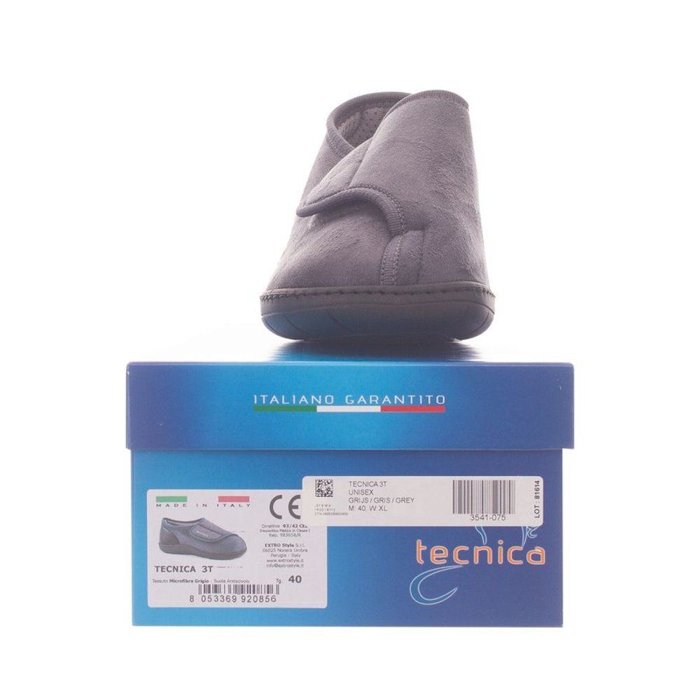 Chaussure grise sur boîte bleue. "Tecnica" est écrit sur la boîte. Taille 40.