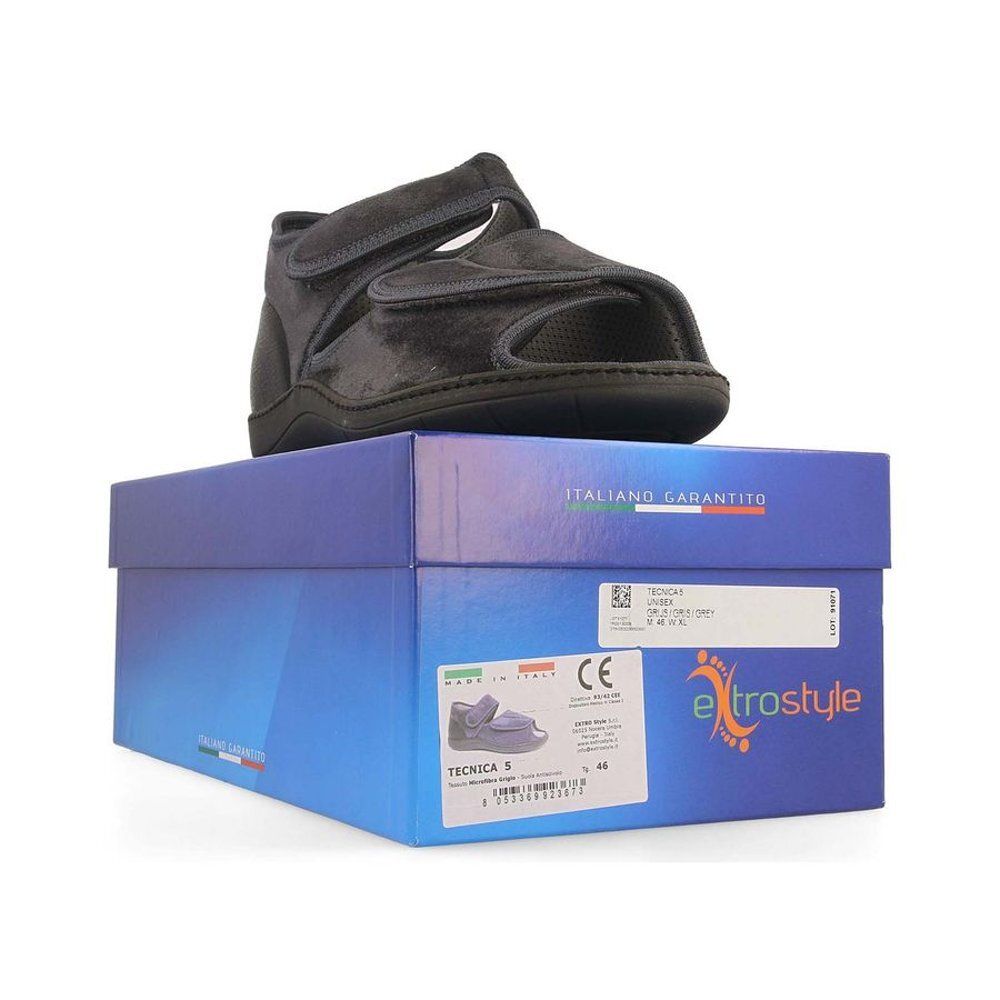 Sandale grise sur boîte bleue. Fermeture velcro, bout ouvert. Étiquette avec informations.