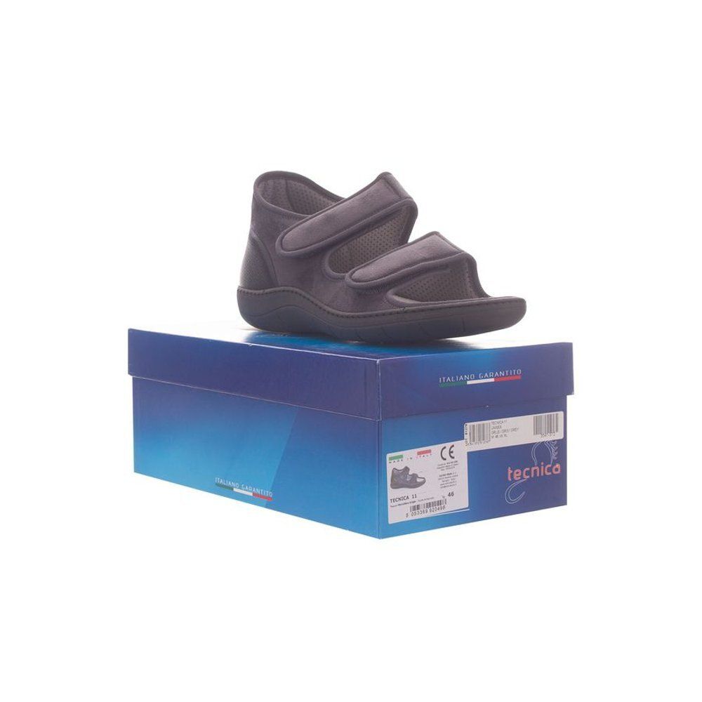 Chaussure grise sur boîte bleue. 'Tecnica' sur la boîte. Marquage CE.
