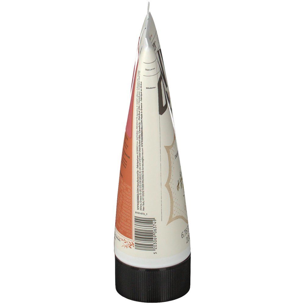 Zijaanzicht van de tube. Wit, met tekst en roze vlak. Zwarte dop. Gesloten punt.