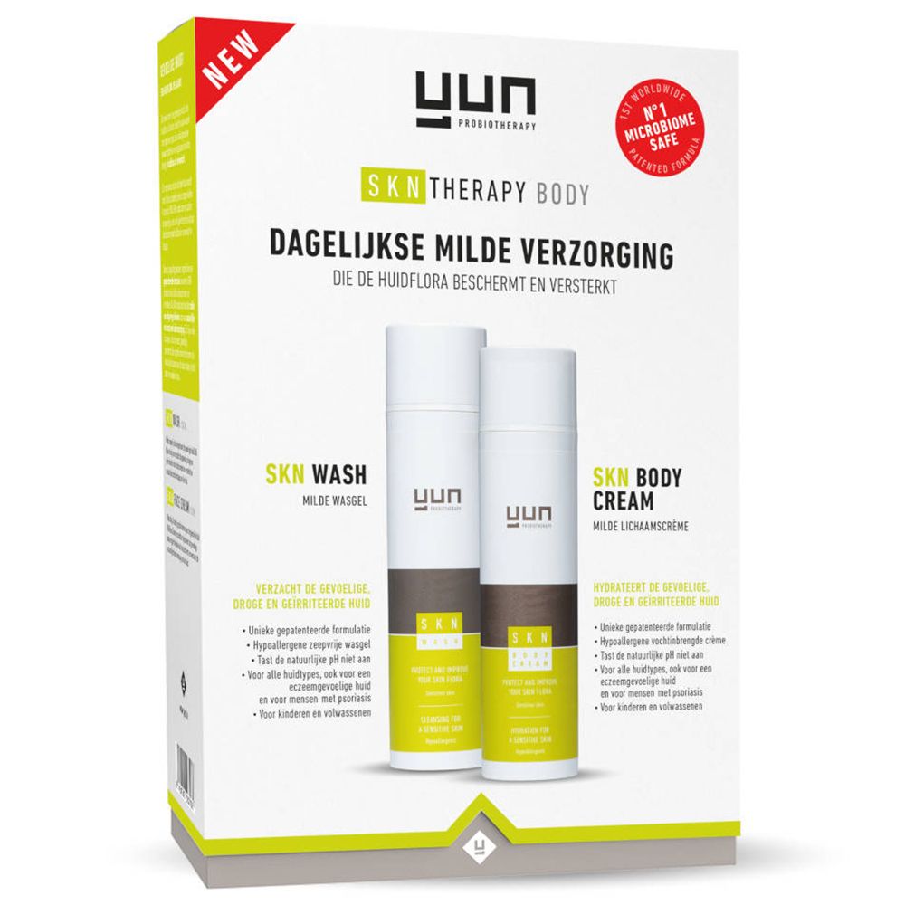 Verpakking met SKN Wash en SKN Body Cream. Witte flessen met bruine en groene accenten. Opschrift YUN. Labels « Nieuw » en « Microbiome Safe ».