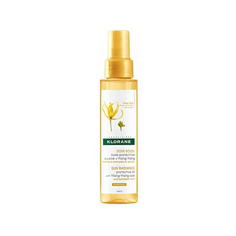 Gele sprayfles met gouden dop. Etiket met productnaam en bloemenillustratie. Merk: KLORANE.