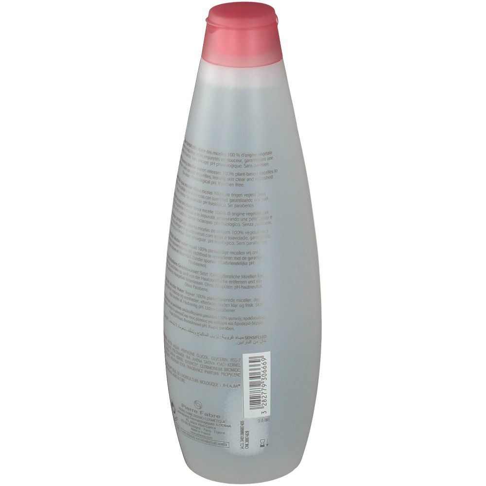 Flacon transparent avec bouchon rose. Texte sur le flacon. Étiquette avec informations et code-barres.