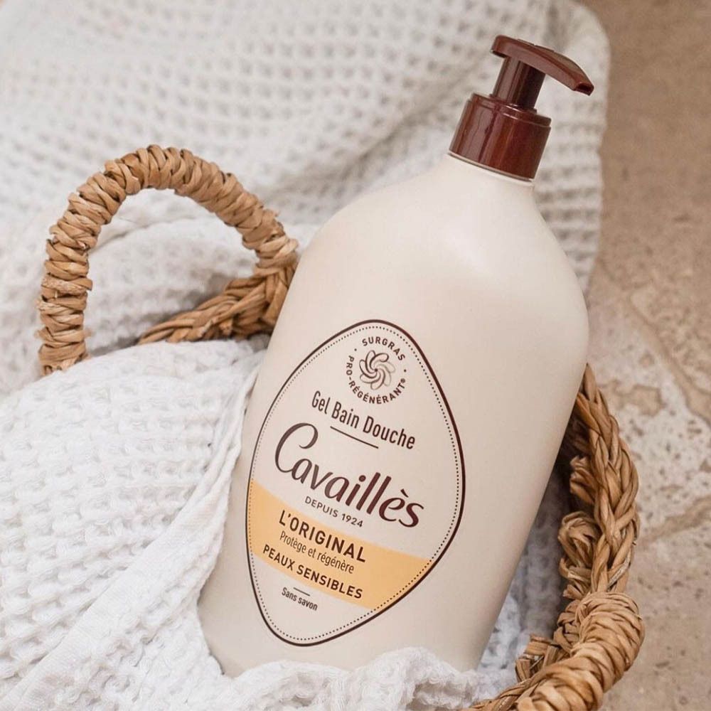 Beige fles in een mand. Opschrift: Cavaillès, L'ORIGINAL, Peaux sensibles. Gel Bain Douche. Op witte doek.