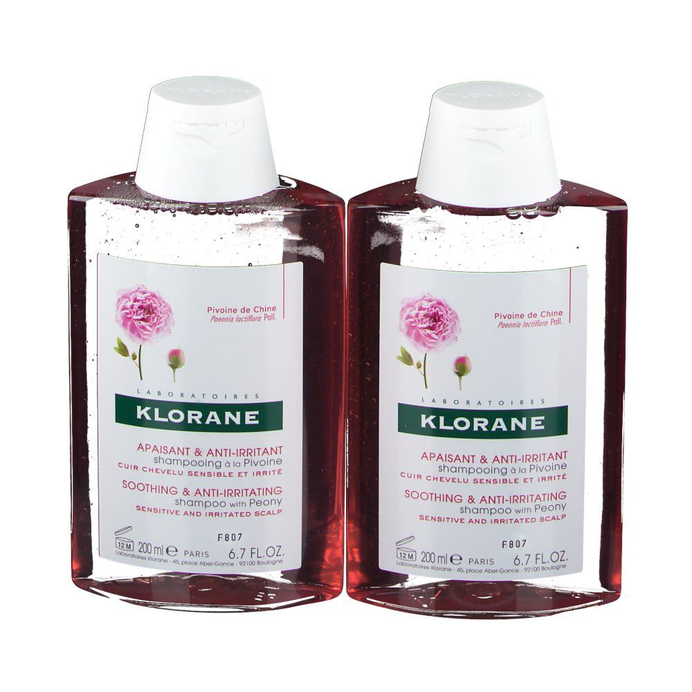 Twee shampoo flessen met witte doppen. Etiket met tekst en pioenroos afbeelding. Productnaam: KLORANE Shampoo met pioenroos.