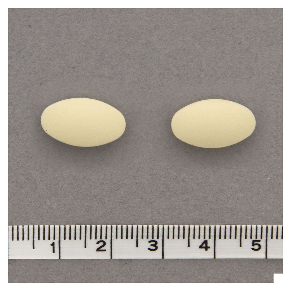 Twee ovale, crèmekleurige tabletten op een grijze ondergrond. Een liniaal eronder.