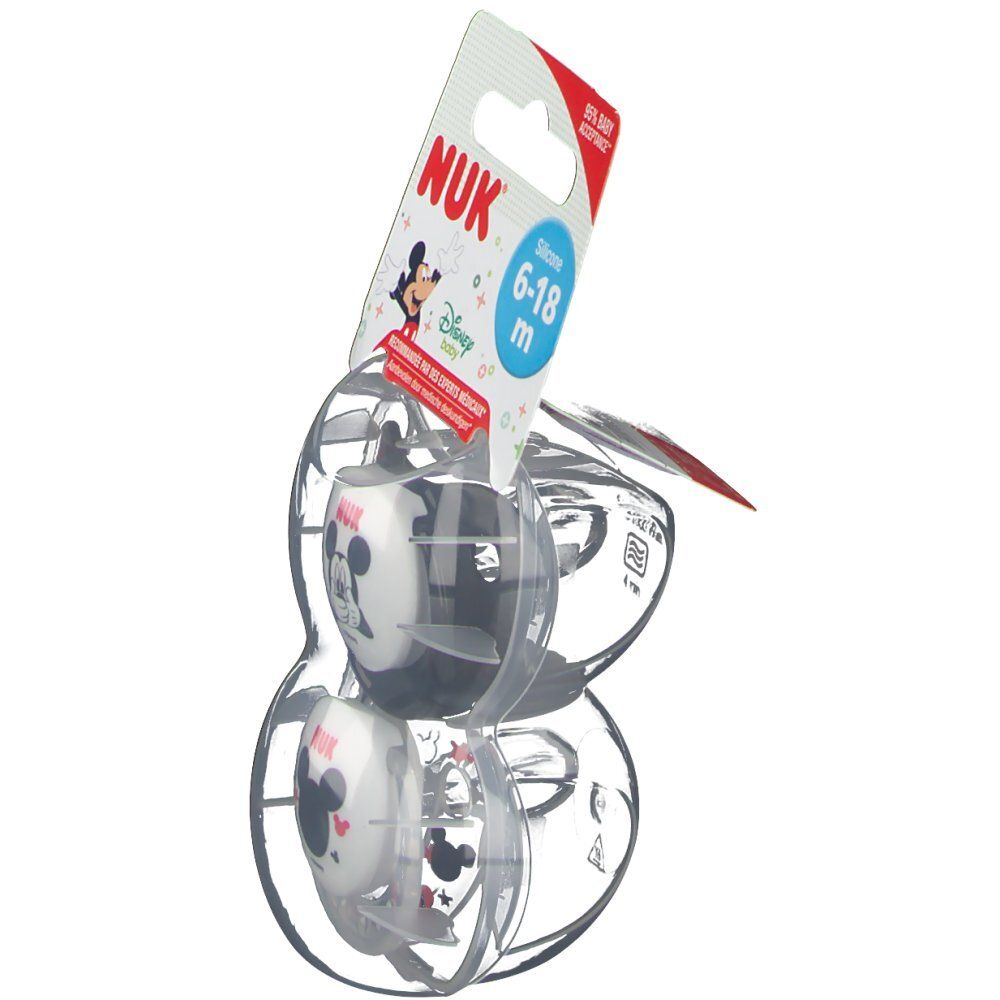 Deux sucettes dans un emballage transparent. L'emballage montre le logo NUK, Mickey Mouse et une recommandation d'âge.