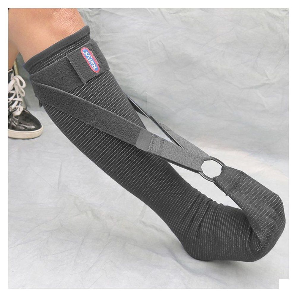 Grijze Plantaire Fascie Brace. Gedragen op been. Merk Rafys. Zwarte banden en metalen ring.