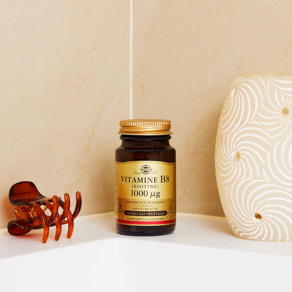 Bruine fles met gouden dop. Staat op een wit oppervlak naast een haarclip.