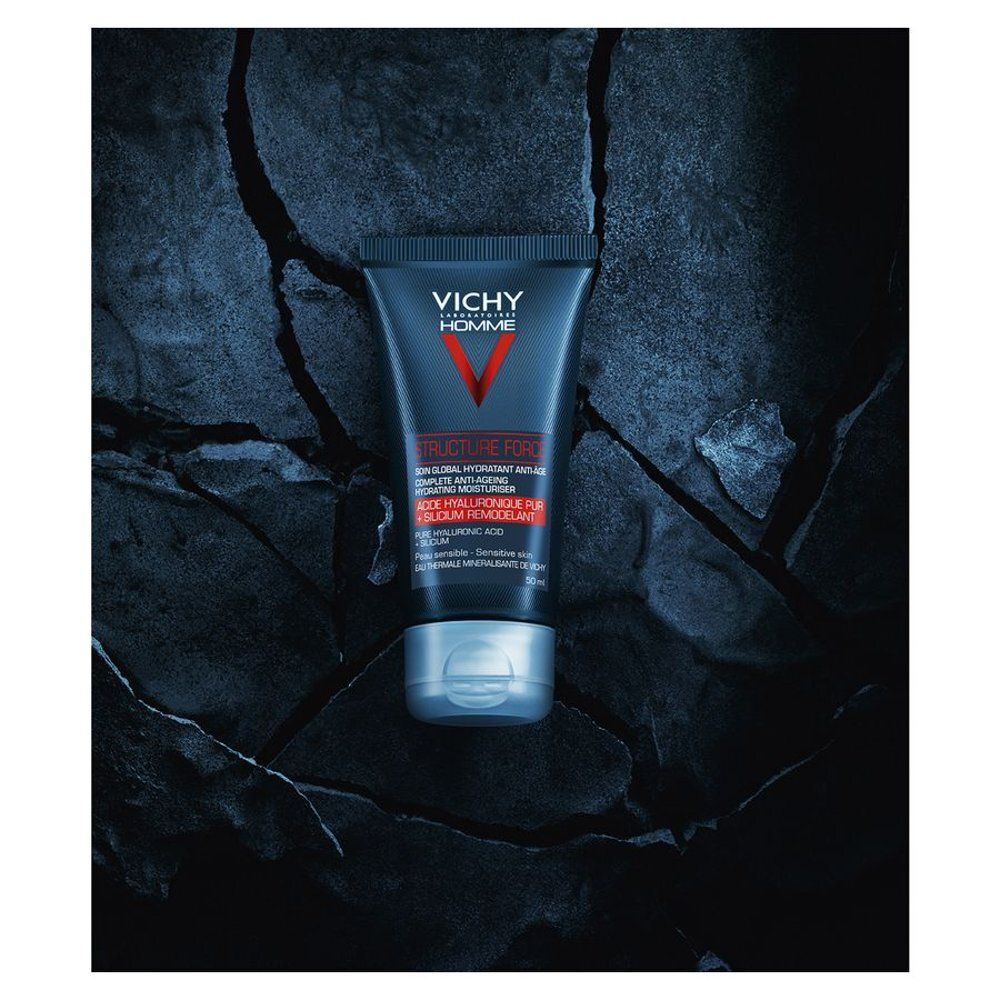 Blauwe tube met VICHY Homme. Bevat Structure Force, hydraterende verzorging. Op stenen achtergrond.