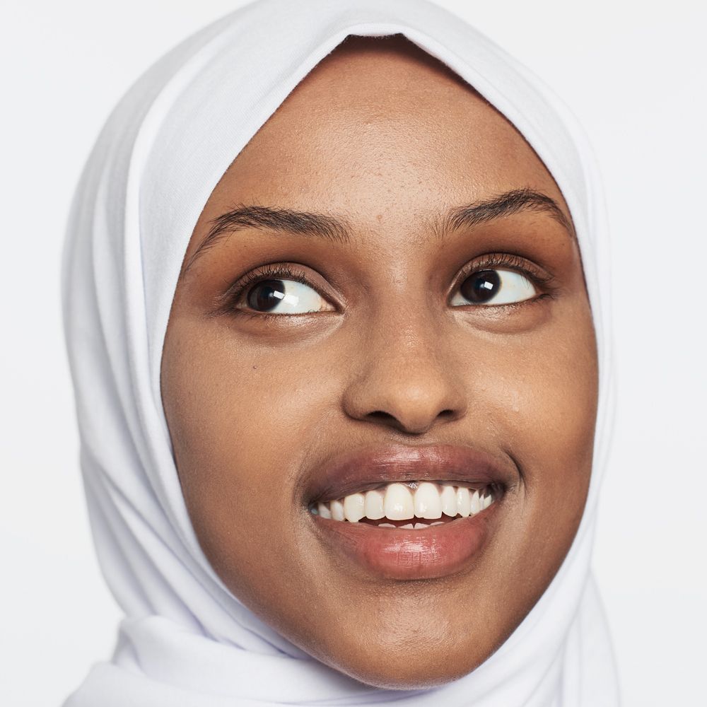 Portret van een vrouw met hijab. Ze glimlacht. Huidtint en gelaatstrekken duidelijk zichtbaar.