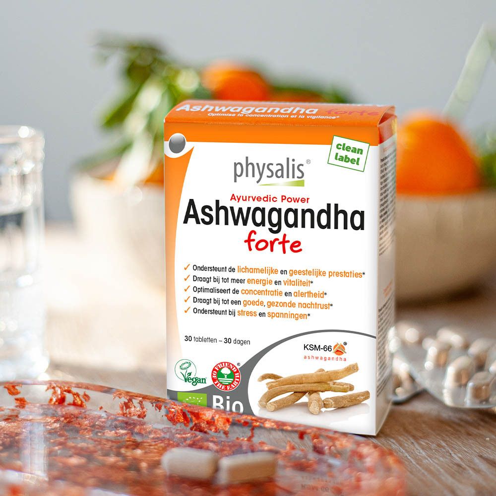 Verpakking van physalis® Ashwagandha forte op tafel. Achtergrond met fruit. Bevat 30 tabletten. Bio-label.