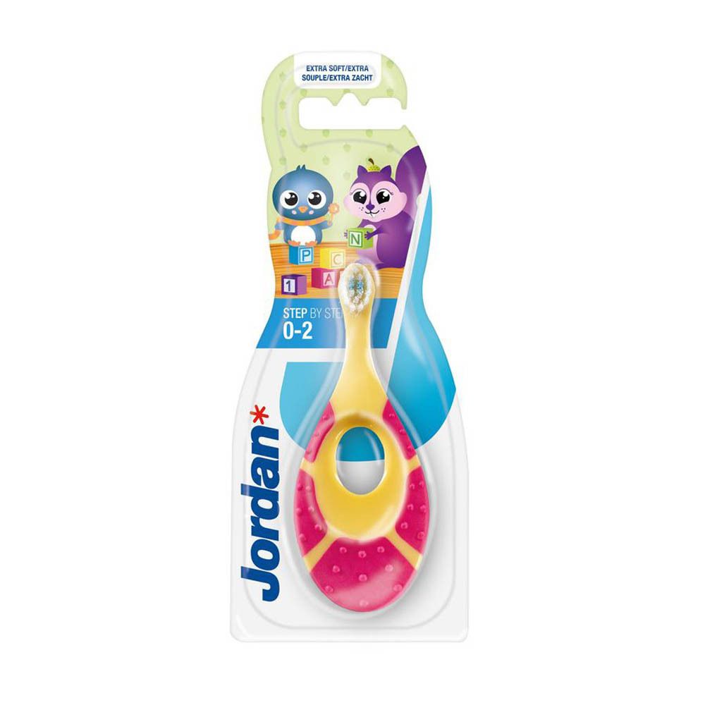 Brosse à dents rose et jaune pour bébé, emballée. Manche percé, poils blancs. Marque Jordan. Pour 0-2 ans.