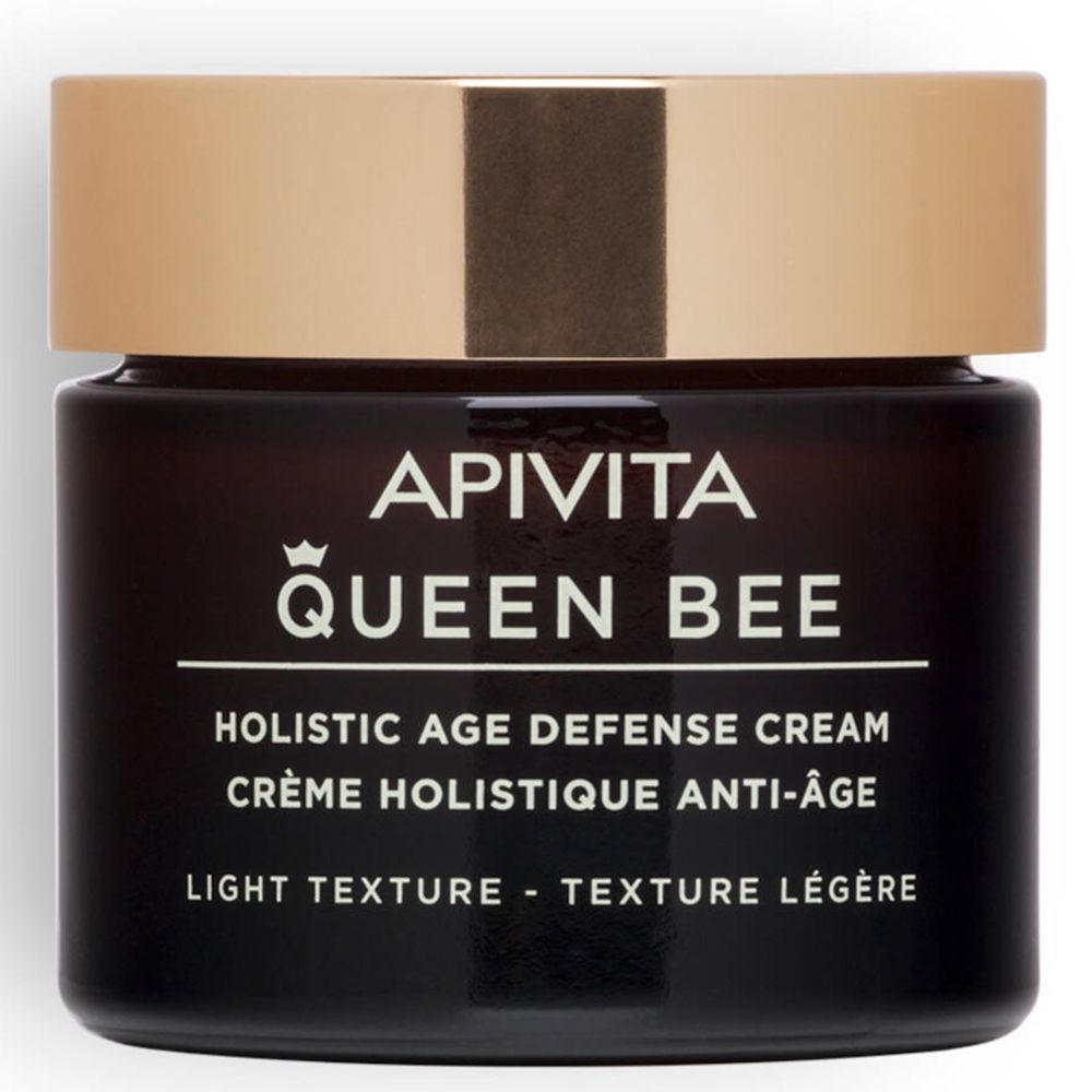 Pot en verre brun foncé avec couvercle doré. Inscription : APIVITA QUEEN BEE, Holistic Age Defense Cream, Texture légère.
