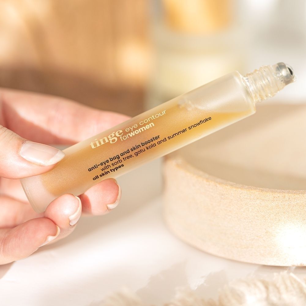 Hand houdt Tinge Eye Contour for women flacon vast.