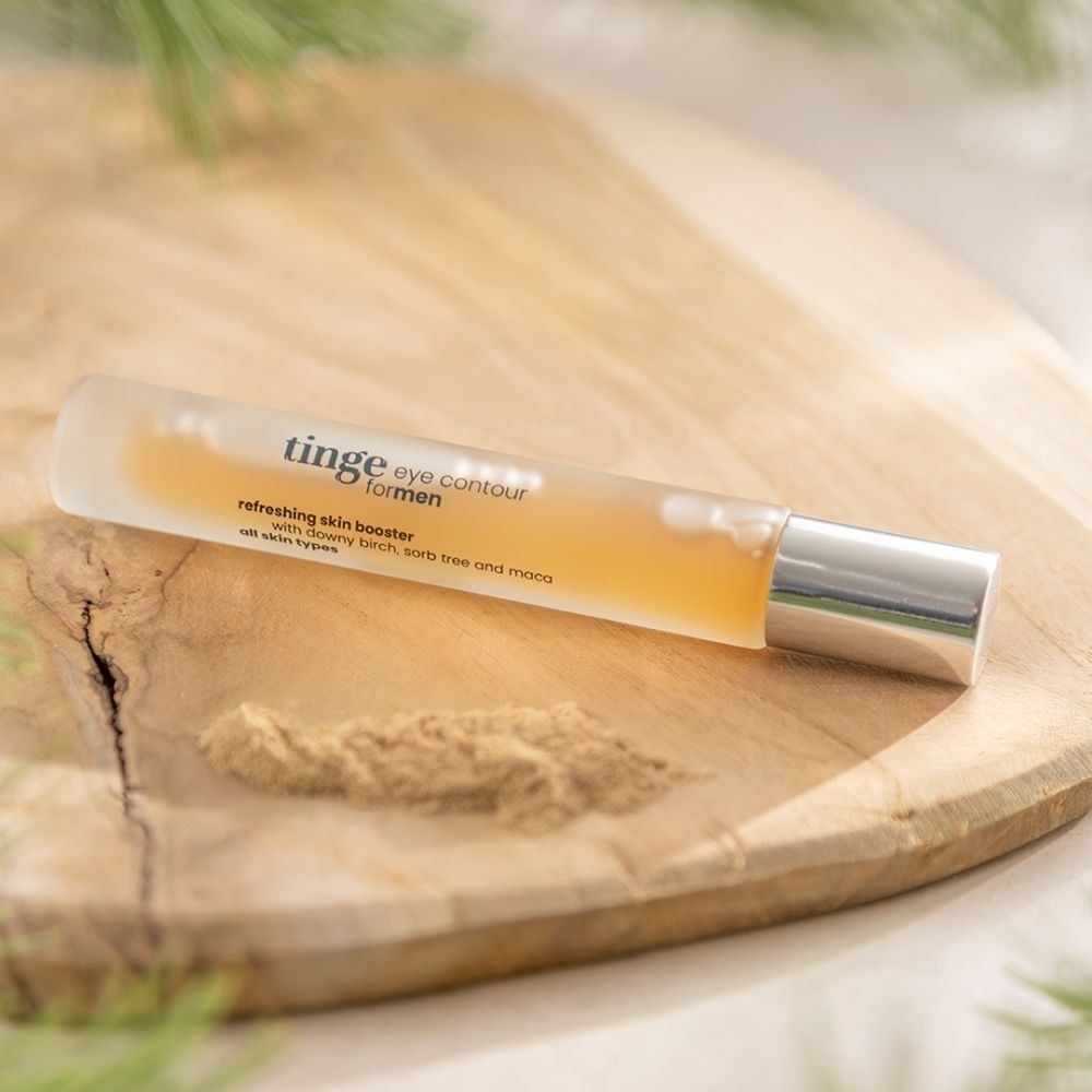 Tinge Eye Contour Roller op houten plank. Verfrissende booster met berkenextract poeder.