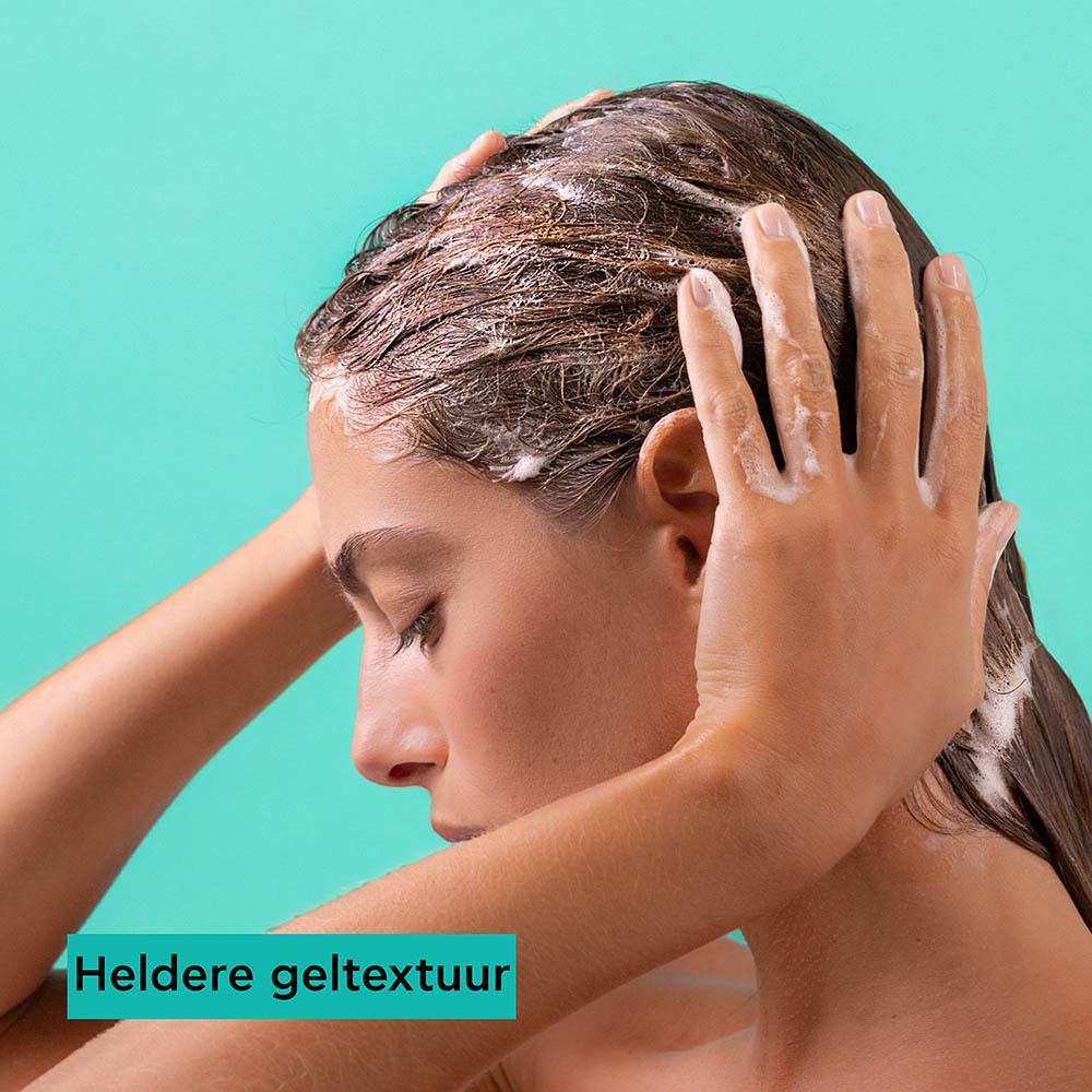 Een vrouw masseert haar haar dat bedekt is met shampoo. Tekst beschrijft de heldere geltextuur.