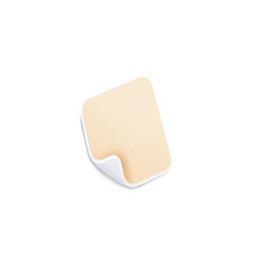 Pansement carré aux coins arrondis. Mousse beige, bordure blanche. Partiellement décollé.