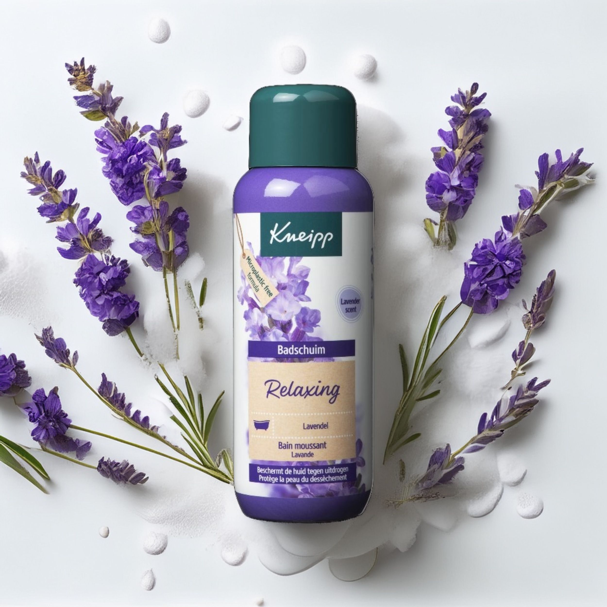 Fles Kneipp Badschaum Lavendel, omringd door lavendelbloemen. Paarse fles met groene dop. Etiket met productnaam.