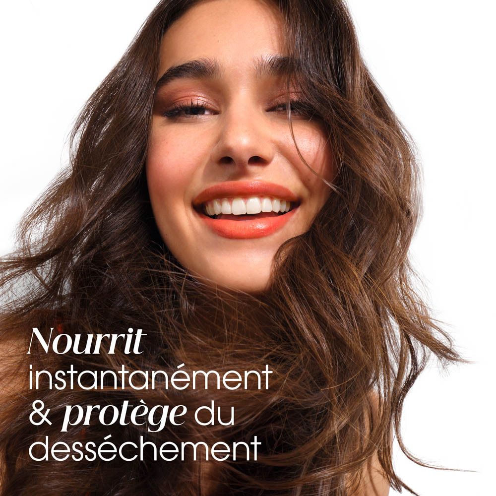 Femme aux cheveux volumineux et brillants nourris par le KLORANE Mango Conditioner.