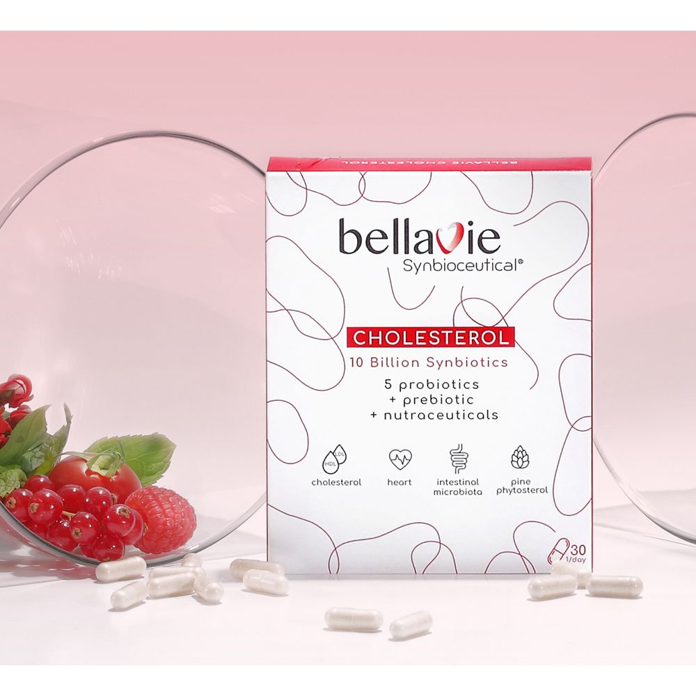 Boîte BellaVie Cholesterol et gélules. Emballage rouge et blanc. Groseilles rouges et anneaux de verre en arrière-plan.
