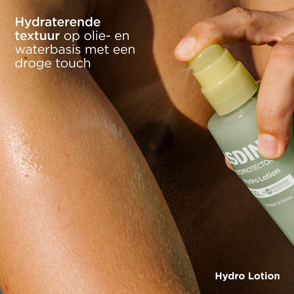 ISDIN Hydro Lotion SPF 50+ vaporisé sur le bras. Flacon jaune-vert. Texte.