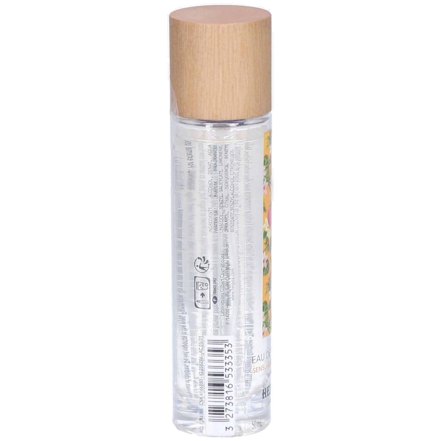Vue arrière du flacon cylindrique. Bouchon en bois. Étiquette jaune à motifs floraux. Texte et code-barres. Liquide transparent visible.