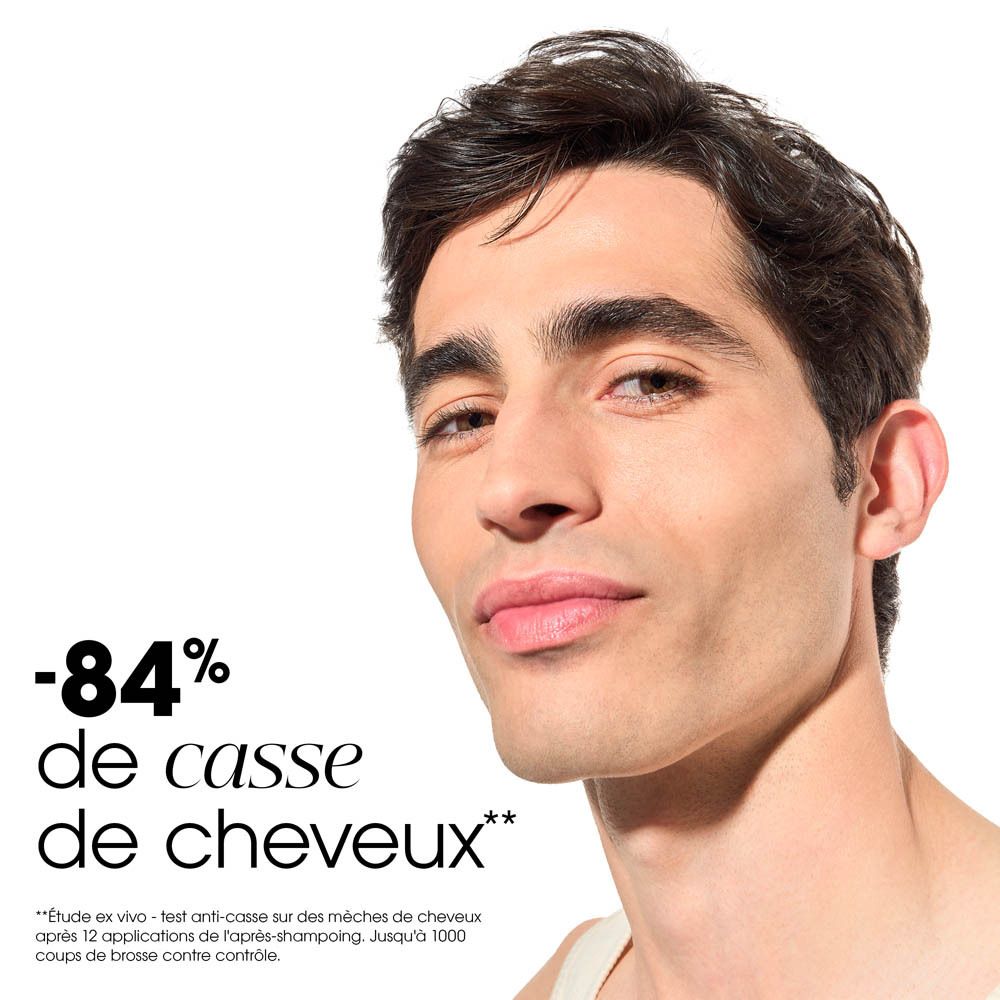 Gros plan d'une crème blanche. Texture fluide & légère. Démêlage facile. Parfum boisé.