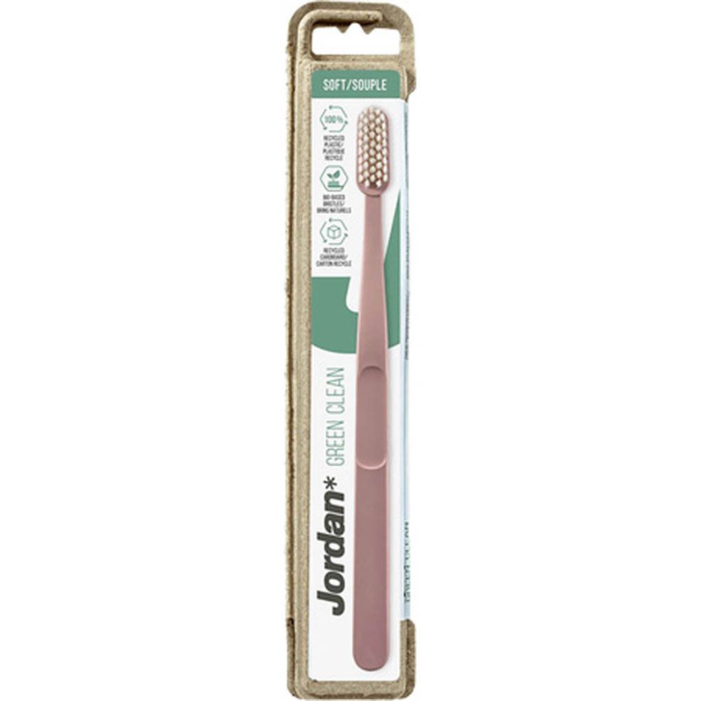 Tandenborstel in verpakking. Roze handvat, witte borstelkop. Merk Jordan Green Clean. Kartonnen verpakking.