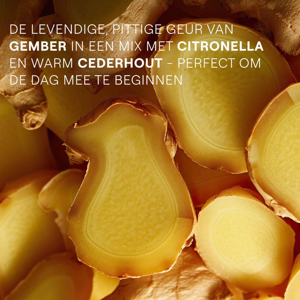 Vrouw onder de douche. Gele Weleda Energy douchegel tube op de achtergrond. Schuim op de huid.
