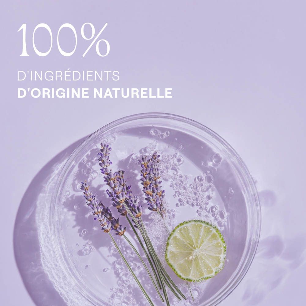 Récipient en verre avec brins de lavande et tranche de citron vert. Texte: 100% d'ingrédients d'origine naturelle.