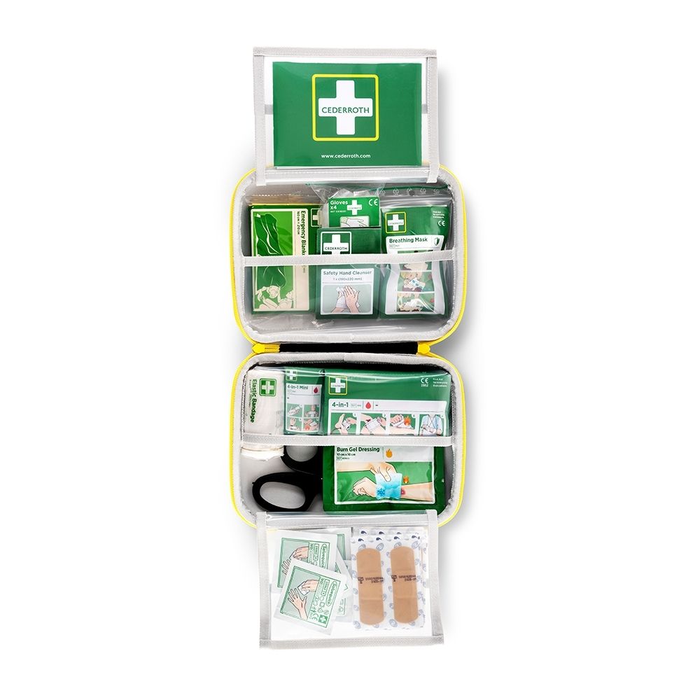 Boîte de premiers secours verte fermée avec bordure jaune. L'étiquette blanche montre une croix rouge et des icônes pour plaies, respiration, circulation, brûlures, chutes.
