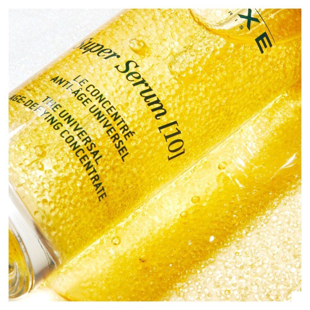 Close-up van geel serum met opschrift: Super Serum [10], Le concentré anti-âge universel.