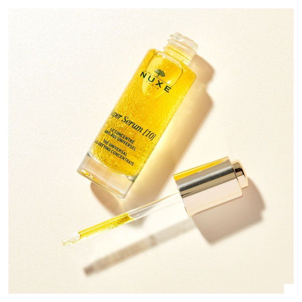 Geel serum in glazen fles met gouden dop en pipet. Opschrift: NUXE, Super Serum [10].