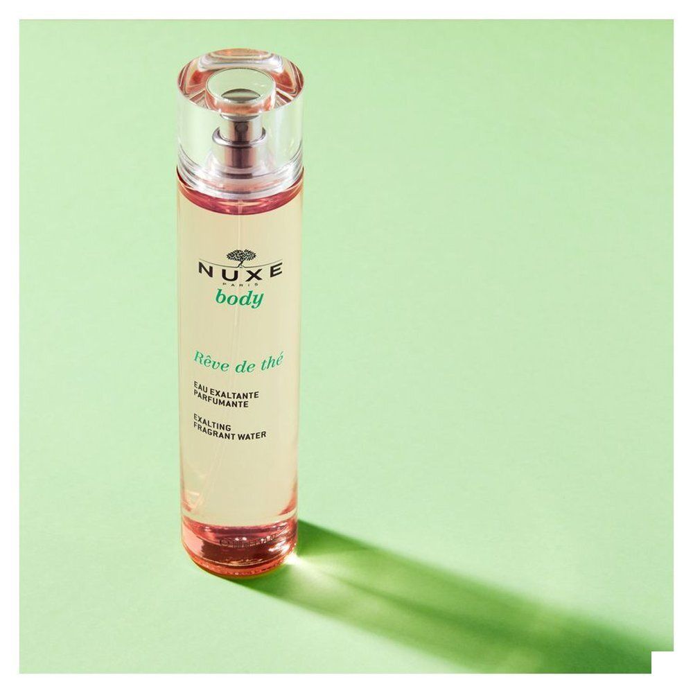 Cilindrische fles met verstuiver. Opschrift: NUXE body, Rêve de thé, Eau exaltante parfumante, Exalting fragrant water.