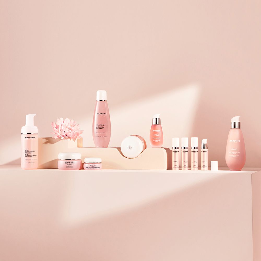 Divers produits sur socle rose. Flacons, pots, tubes. Texte : Darphin.