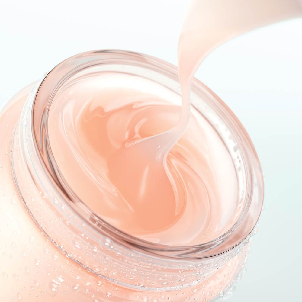 Un pot en verre contenant une crème rose pâle versée à l'intérieur.
