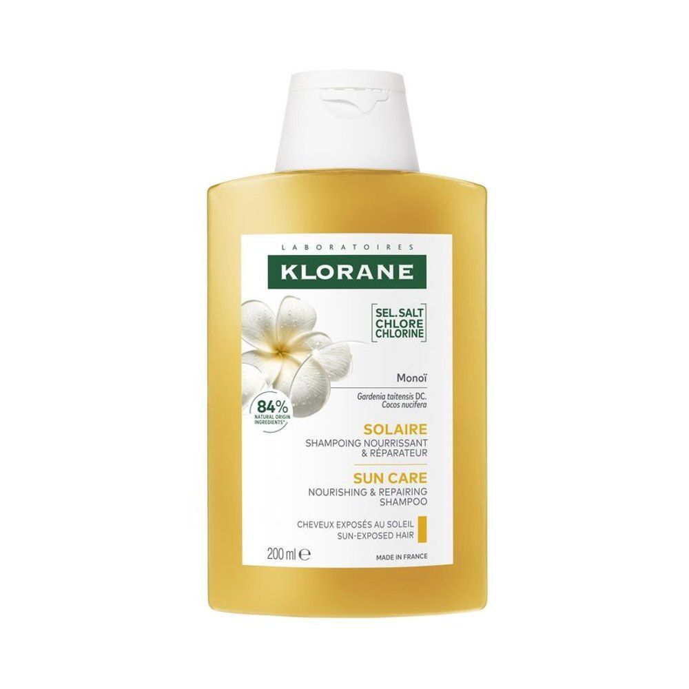 Flacon de shampooing jaunâtre avec bouchon blanc. Inscription Klorane, Solaire, Shampooing Nourrissant & Réparateur. 84% ingrédients d'origine naturelle.