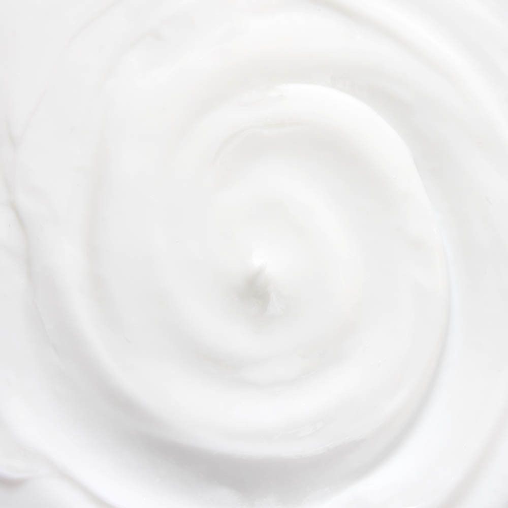 Gros plan d'une crème blanche. La crème est disposée en spirale.