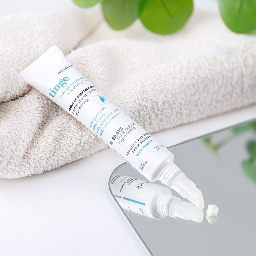 Tinge Advanced Skin Repair & Soothing Cream tube op spiegel. Nederlandse tekst.