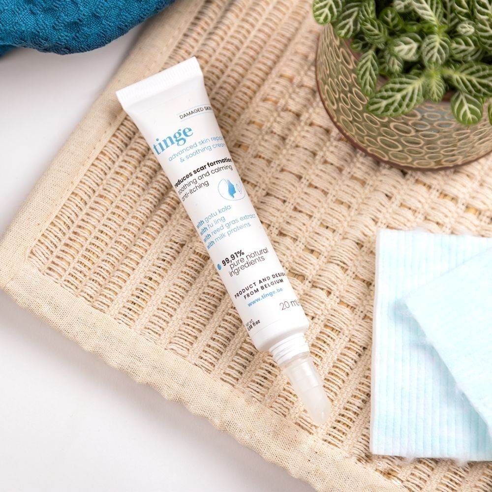 Tinge Advanced Skin Repair & Soothing Cream tube op textuur. Nederlandse tekst.