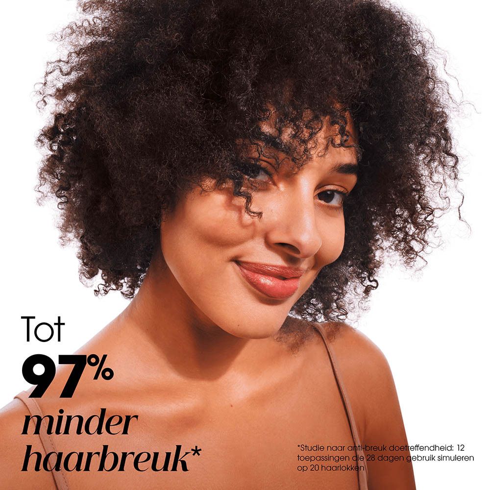 Vrouw met vol, krullend haar en een glimlach.