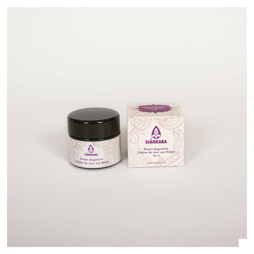 Pot et boîte de crème. Inscription : Sjankara, Crème de jour aux roses. Logo et texte violets sur fond blanc.