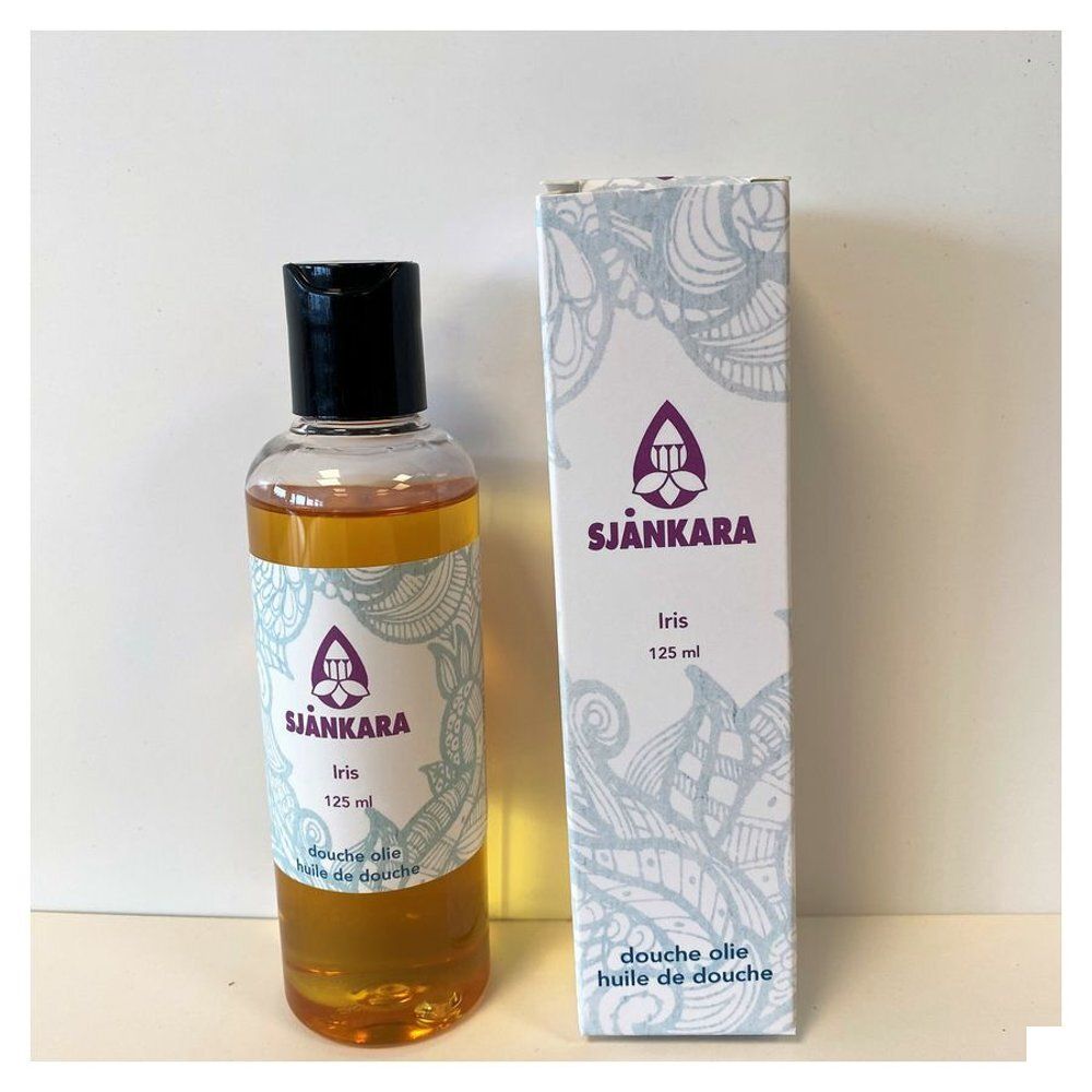 Fles en doos met product. Opschrift: Sjankara Iris 125 ml. Fles met zwarte dop, gelige vloeistof. Doos met bloemmotief.