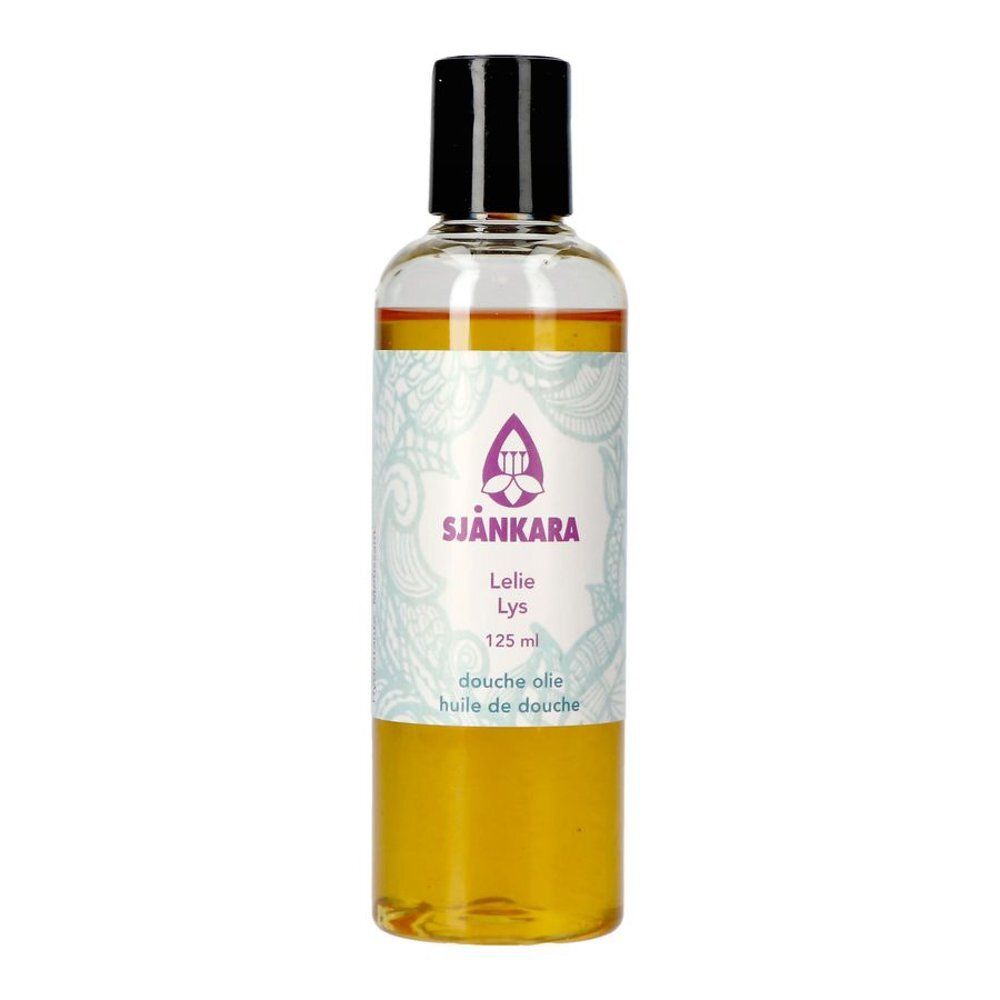 Transparante fles met gele vloeistof en zwarte dop. Etiket met logo en tekst. Productnaam: Sjankara Huile de Douche au Lys.