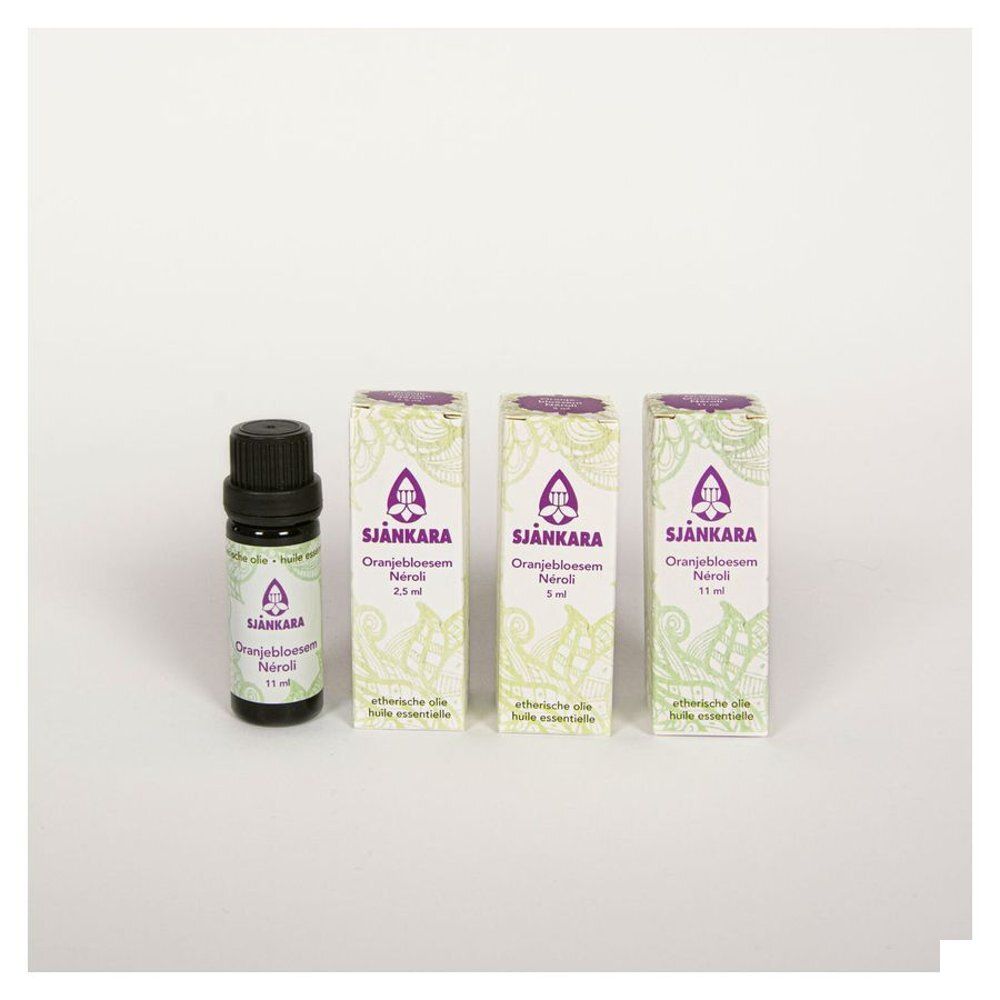 Une bouteille et trois boîtes avec le logo Sjankara. Inscription : Oranjebloesem Neroli, huiles essentielles.